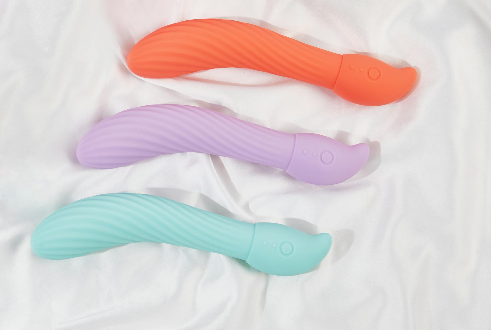 Různobarevné vibátory Hello Nancy rozložené na žlutém pozadí, představující různorodost a design.